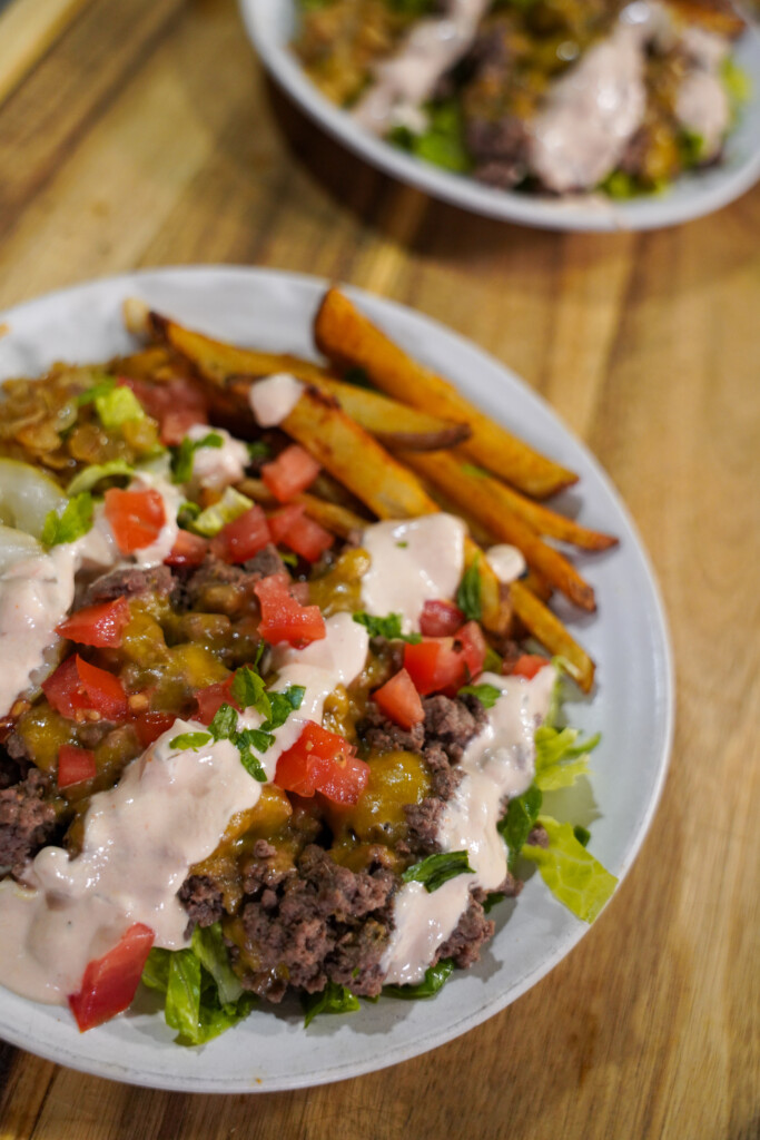 Animal Style Venison Burger Bowls with ground venison, crispy fires, caramelized onions, diced tomatoes and pickles.