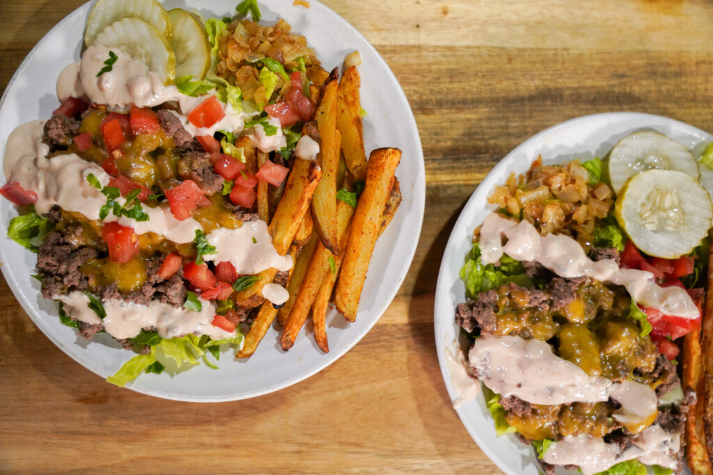 Animal Style Venison Burger Bowls with ground venison, crispy fires, caramelized onions, diced tomatoes and pickles.